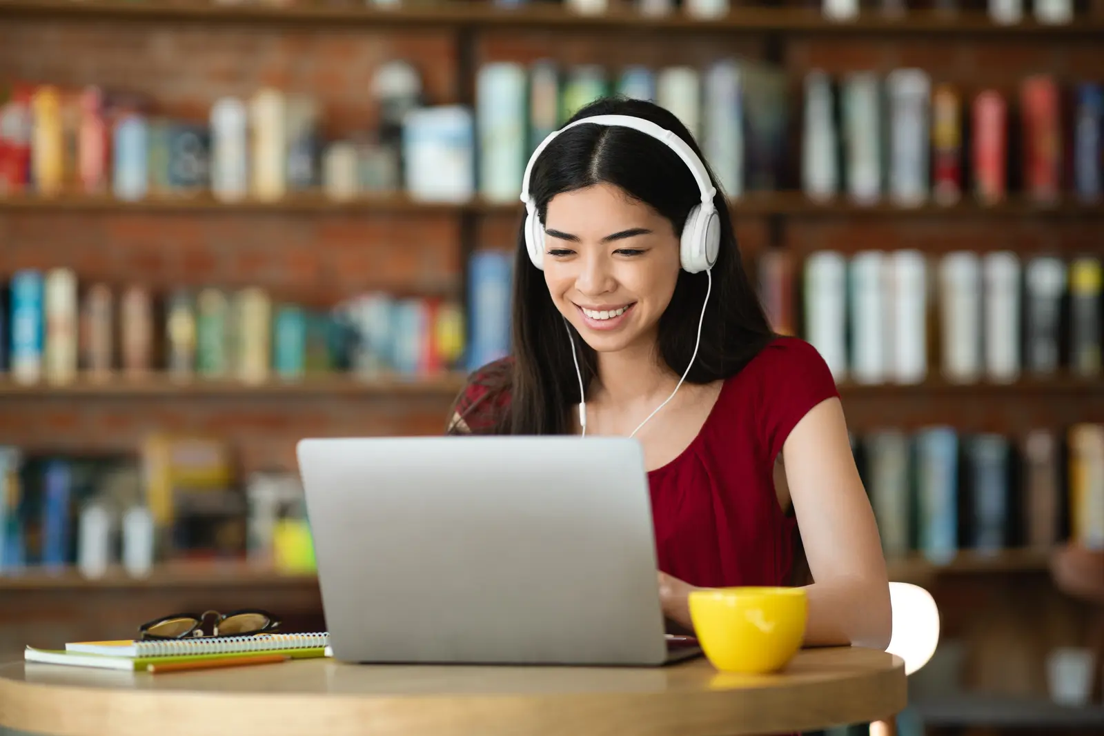 Freelancer working on laptop with headphones in a cafe